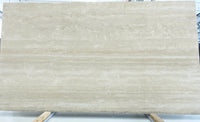 Beige marble slab with visible veins on a white background